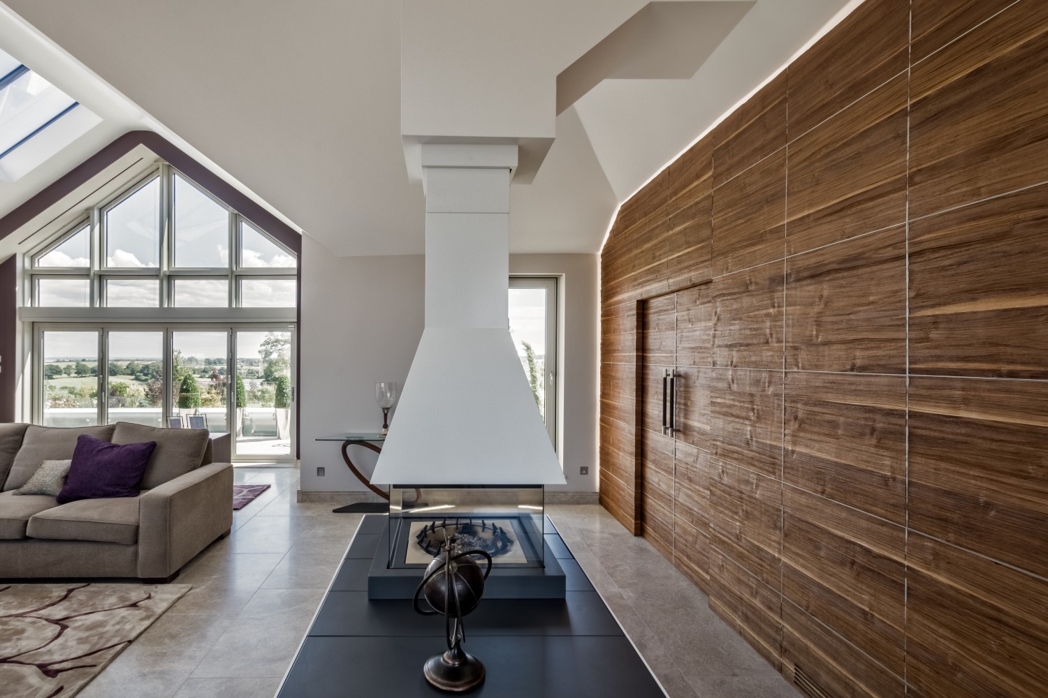 Luxurious cinema room with hidden TV in wooden wall panel.